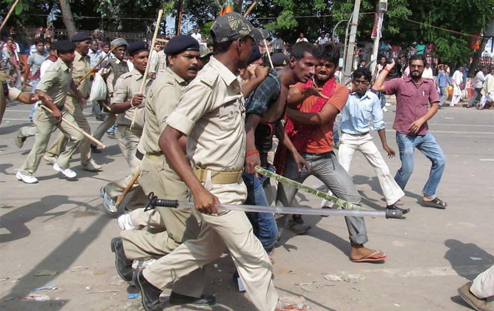 People thrash a man whom the police detain and take away for questioning after a bomb blast outside the venue of a political rally in Patna.