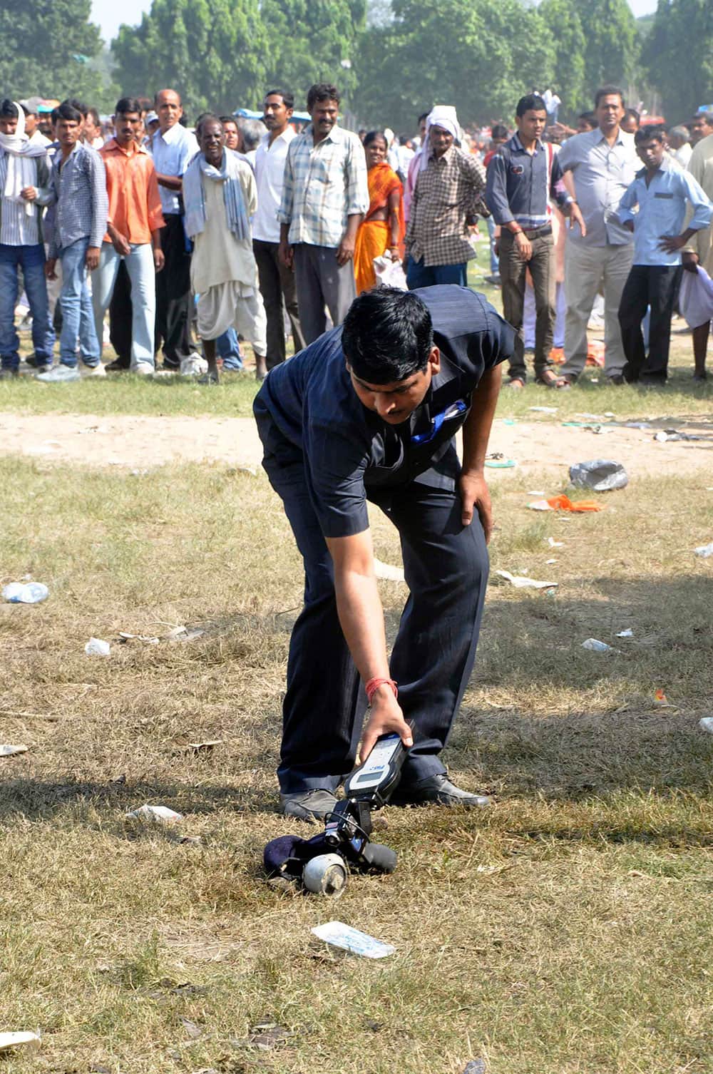 An Indian policeman collects evidence from the spot of a bomb blast outside the venue of a political rally in Patna.
