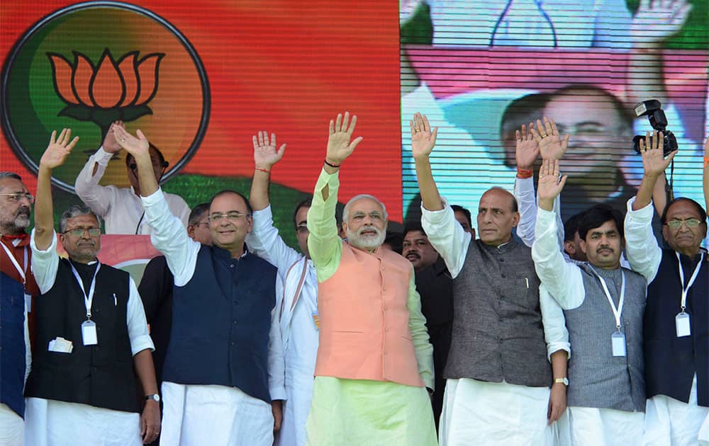 India`s main opposition Bharatiya Janata Party (BJP)`s prime ministerial candidate Narendra Modi, center in saffron jacket, and other leaders wave at a rally in Patna.
