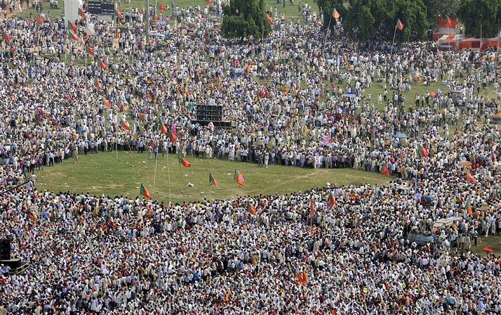 People gather around as officials prepare to defuse a bomb outside the venue of a political rally in Patna.