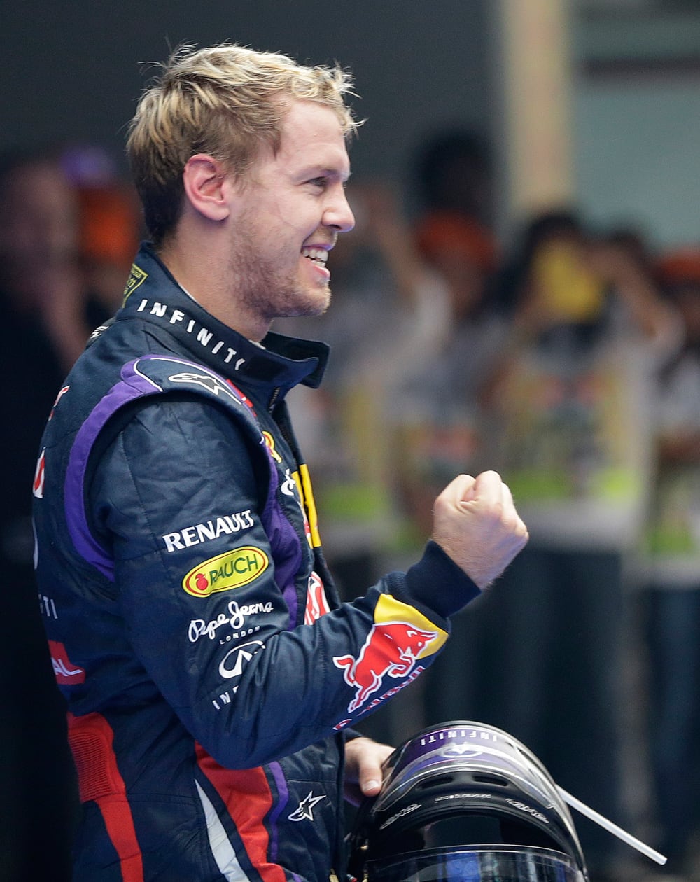 Red Bull driver Sebastian Vettel of Germany gestures to his team crowd after winning the Indian Formula One Grand Prix and his 4th straight F1 world drivers championship at the Buddh International Circuit in Noida, India.