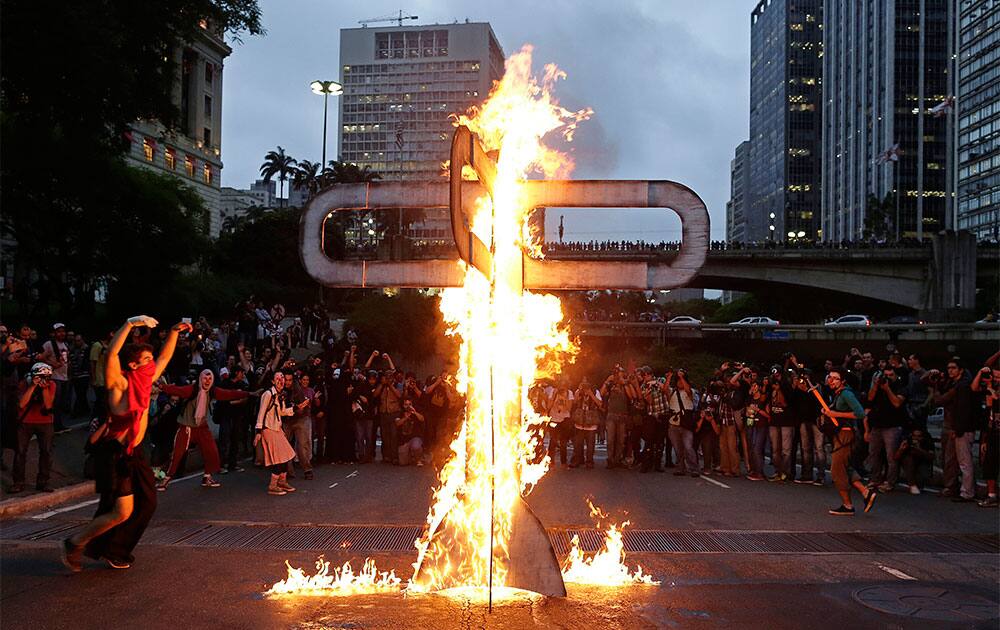 Demonstrators set fire to a street sculpture in the shape of a bus station turnstile as they protest against Sao Paulo`s Governor Geraldo Alckmin in Sao Paulo, Brazil.