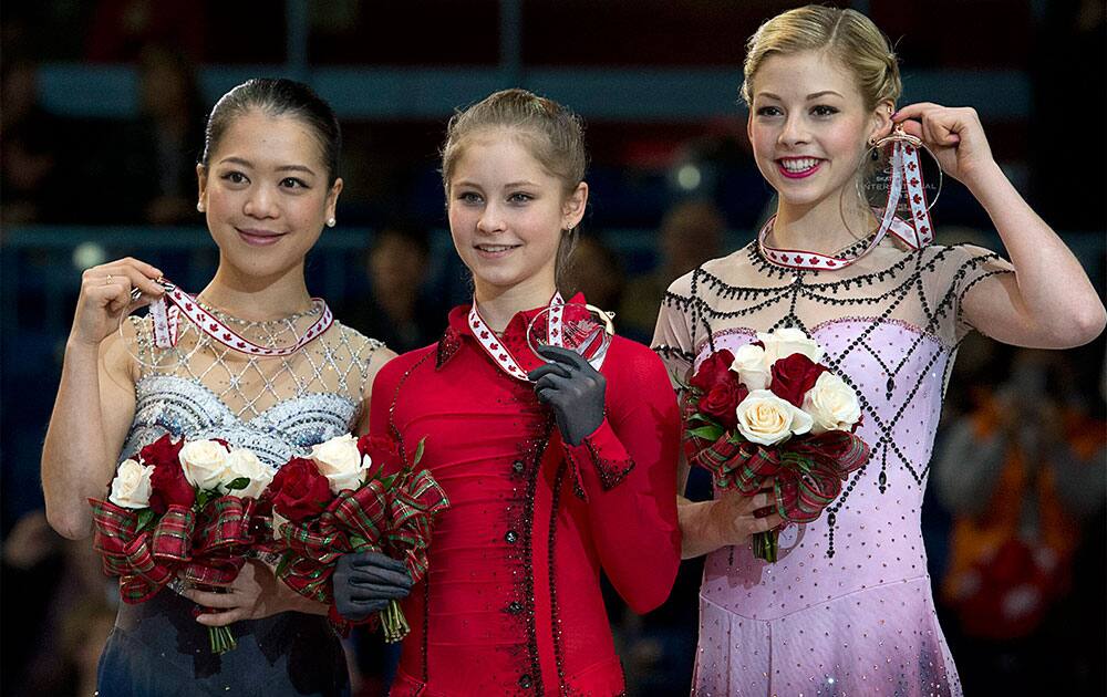 Winner Julia Lipnitskaia, center, of Russia, is flanked on the podium by second-place finsiher Akiko Suzuki, left, of Japan, and third-place finisher Gracie Gold, of the United States, after the ladies competition at the Skate Canada figure skating event in Saint John, New Brunswick.