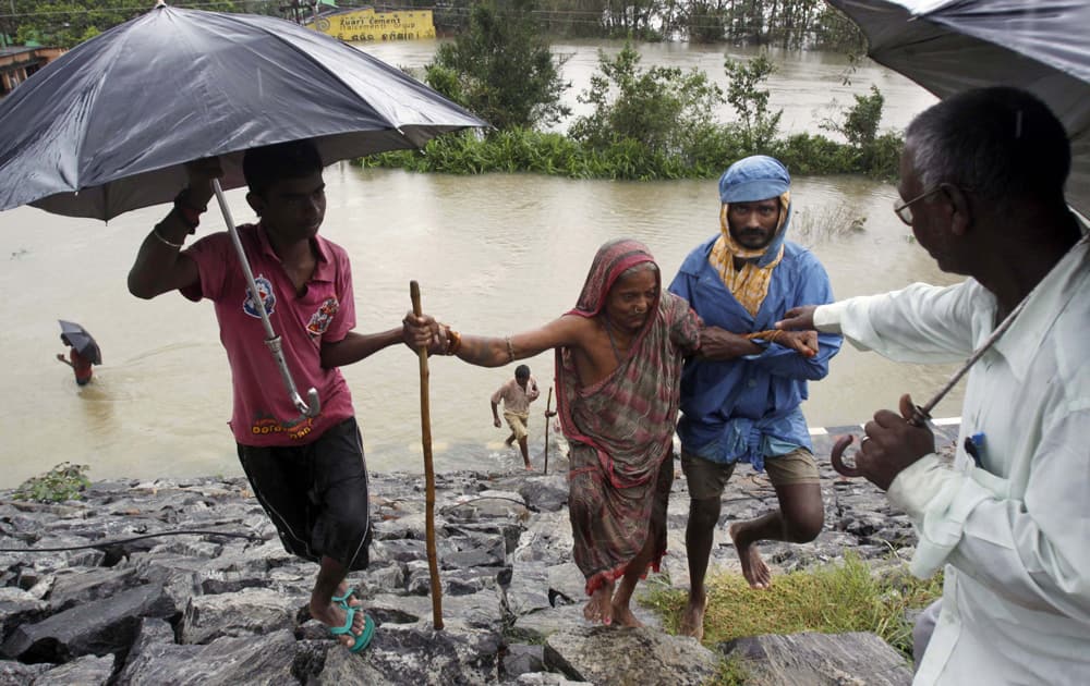Villagers help an elderly woman to safer ground after crossing floodwaters in Khurda district, in the eastern Indian state of Orissa.