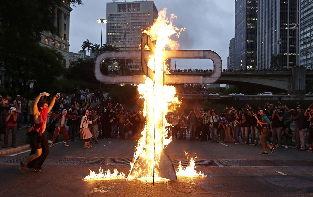 Demonstrators set fire to a street sculpture in the shape of a bus station turnstile as they protest against Sao Paulo`s Governor Geraldo Alckmin in Sao Paulo, Brazil.