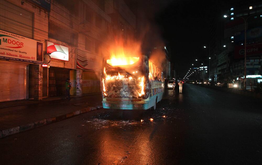A bus stands in flames after it was set afire by opposition supporters trying to defy a ban on protests, in Dhaka.