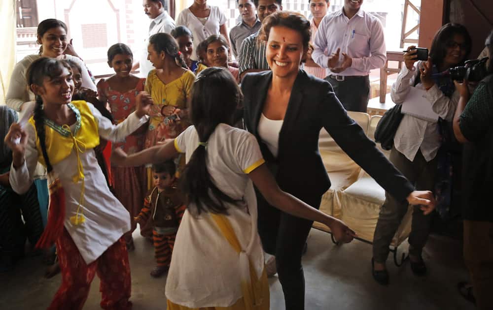 French Women’s Rights Minister Najat Vallaud Belkacem dances with children of a charitable trust Apne Aap Women Worldwide during her visit to the center in New Delhi.