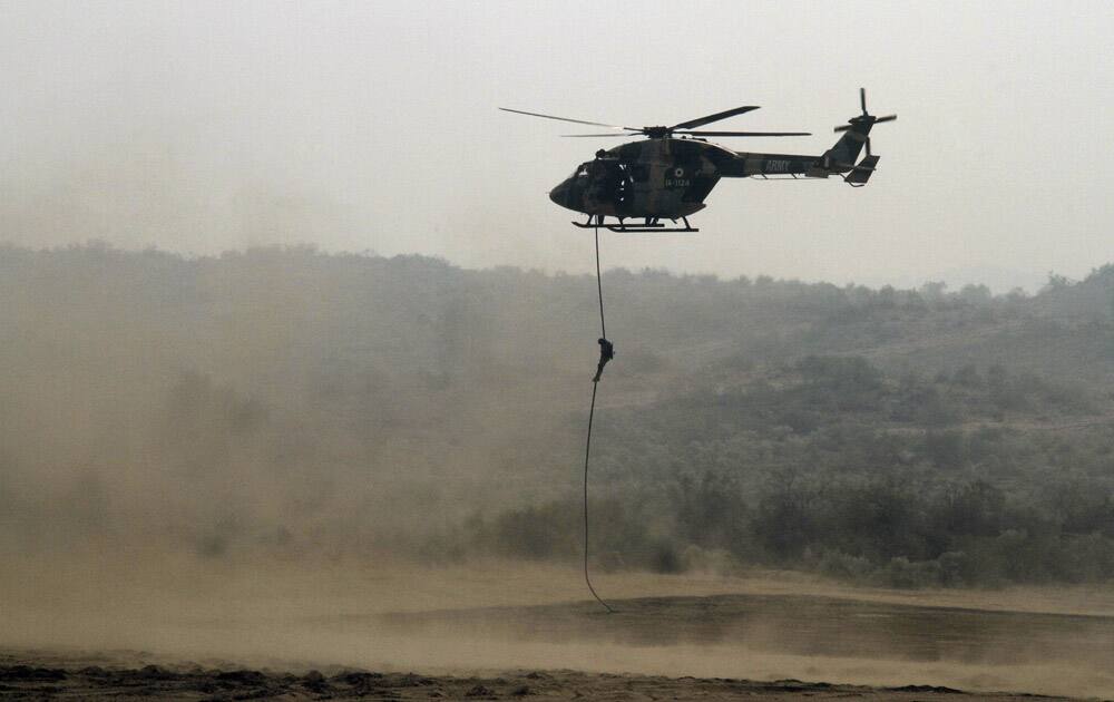 Indian and Russian army soldiers participate in a drill during a joint military exercise at Mahajan Field firing range 150 kilometers (93 miles) south from Bikaner in Rajasthan .