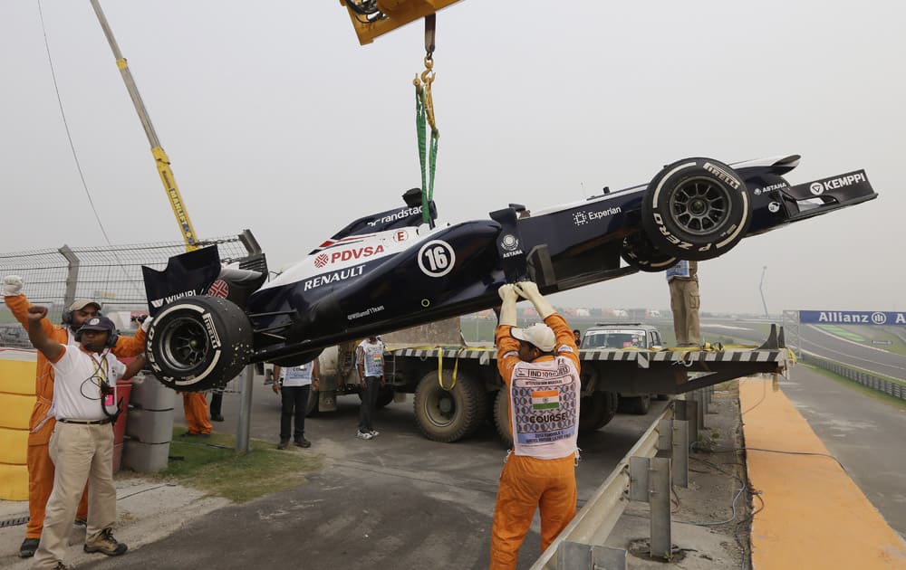 Track marshals place Williams driver Pastor Maldonado of Venezuela;s car onto a truck after his car stopped during the second practice session at the Indian Formula One Grand Prix at the Buddh International Circuit in Noida.