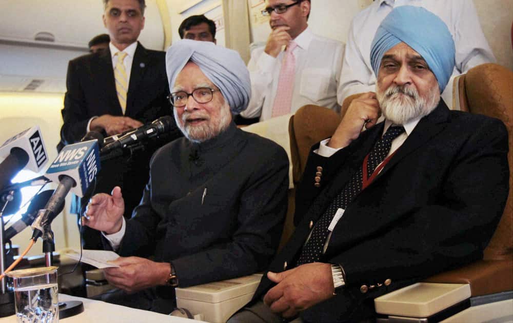 Prime Minister Manmohan Singh with Deputy Chairman of Planing Commission Montek Singh Ahluwalia addressing a press conference on board his special flight on Thursday after his visit to Russia and China.