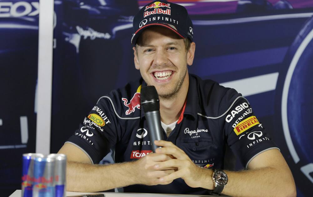 Red Bull driver Sebastian Vettel of Germany smiles during a press conference in his team garage ahead of the Indian Formula One Grand Prix at the Buddh International Circuit in Noida.