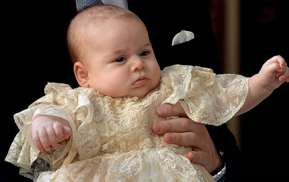 Britain`s Prince George is held by his father Prince William as they arrive at Chapel Royal in St James`s Palace in London, for the christening of the three month-old Prince.