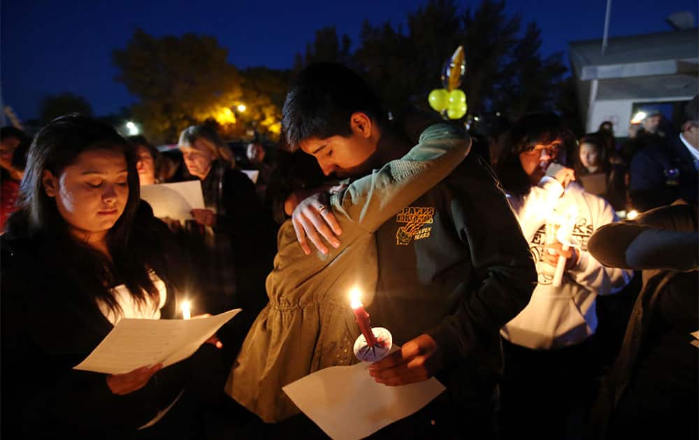 Hundreds of students and residents attend a candlelight vigil at Sparks Middle School in Sparks, Nev., in honor of slain teacher Michael Landsberry and two 12-year-old students who were injured after a fellow student open fire at the school on Monday, before turning the gun on himself.