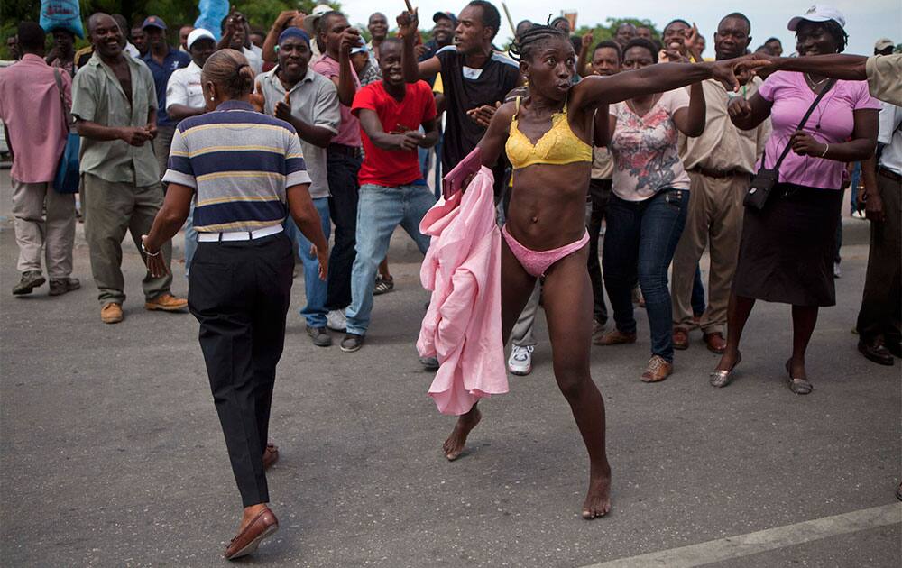 A female protester impersonating the first lady of Haiti, Sophia Martelly, wears the colors of the Martelly Foundation during a protest outside a courthouse in Port-au-Prince, Haiti.