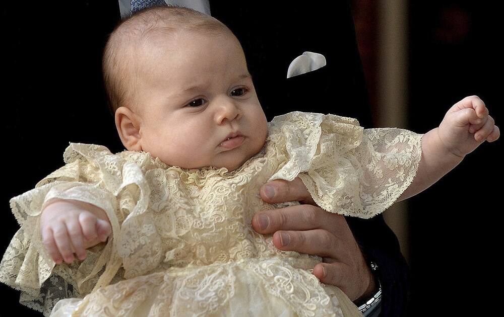 Britain`s Prince George is held by his father Prince William as they arrive at Chapel Royal in St James`s Palace in London, for the christening of the three month-old Prince.