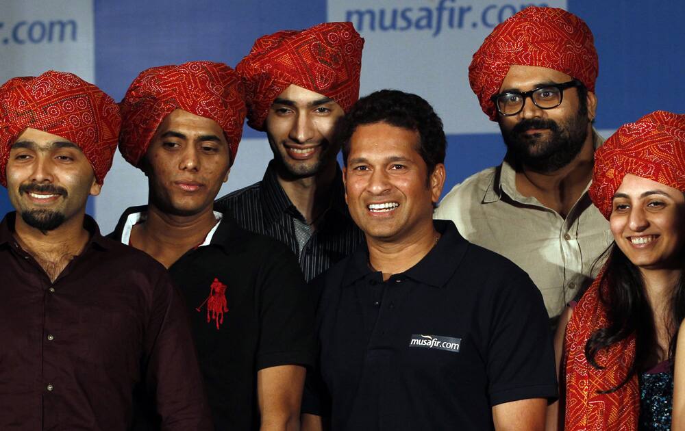 Sachin Tendulkar poses with turban-wearing fans at a news conference where he launched a travel portal in Mumbai.