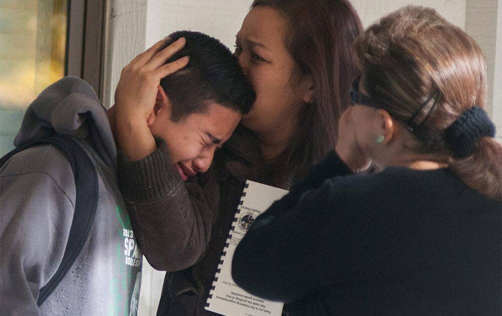A Sparks Middle School student cries and is comforted after being released from Agnes Risley Elementary School, where some students were evacuated to after a shooting at SMS in Sparks, Nev.