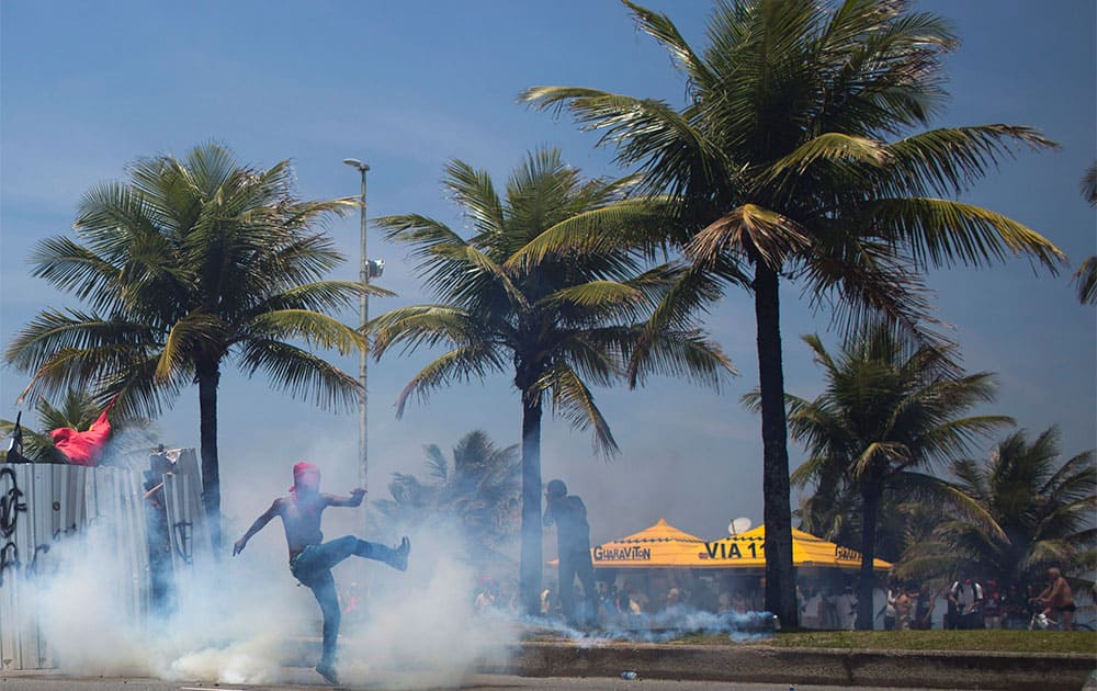 Protesters kick a tear gas canister fired by the National Guard during a protest against the auction of the Libra offshore oil field, near the Windsor hotel where the auction is taking place, on Barra da Tijuca beach in Rio de Janeiro, Brazil.