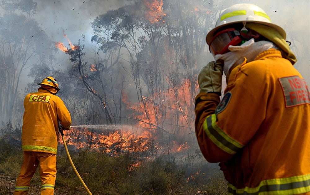 Firefighters work on putting in containment lines to help control a wildfire near the township of Bell, Australia.