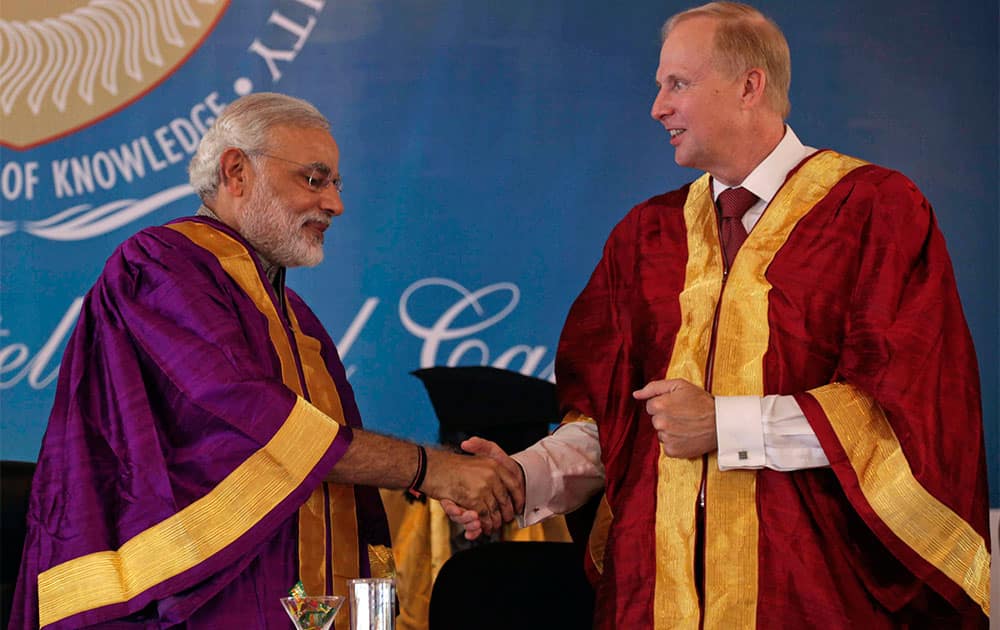 Gujarat state Chief Minister Narendra Modi, left, shakes hand with British Petroleum Group Chief Executive Bob Dudley during the convocation ceremony of Pandit Deendayal Petroleum University (PDPU) in Gandhinagar, in the western Indian state of Gujarat.