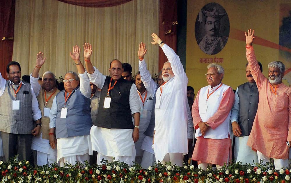 Gujarat CM and BJP`s Prime Ministerial candidate Narendra Modi with party President Rajnath Singh, Lakshmikant Bajpai, Mukhtar Abbas Naqvi and others wave at public during his election campaign rally in Kanpur.