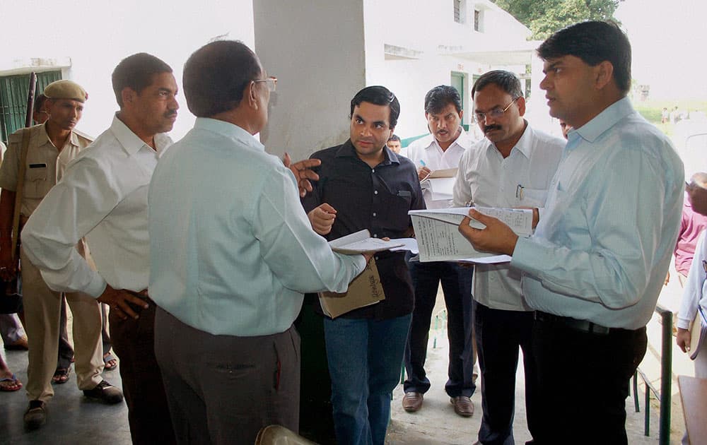 Uttar Pradesh Additional Chief Election Officer Pradesh Alok Tiwari(M) during a review inspection of voters` list at a polling booth in Mirzapur.