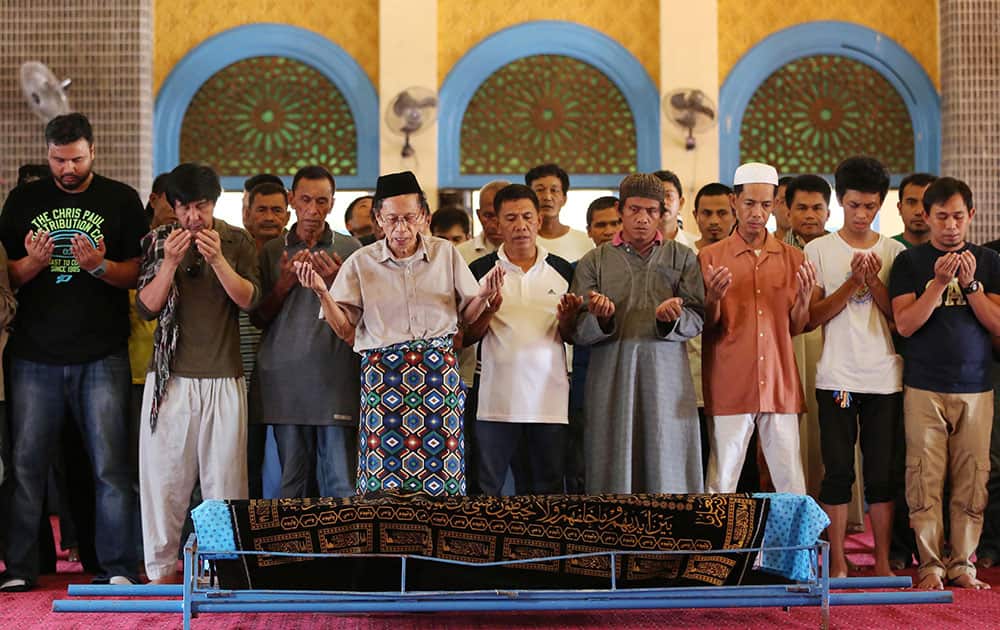 Relatives and followers pray beside the coffin of Filipino Sultan Jamalul Kiram III at the Blue Mosque in Maharlika village in Taguig city, south of Manila, Philippines.