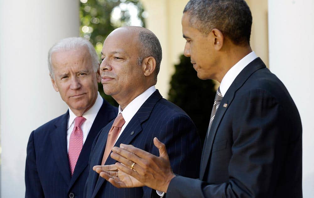 President Barack Obama stands with Jeh Johnson, his choice for the next Homeland Security Secretary, and Vice President Joe Biden in the Rose Garden at the White House in Washington.
