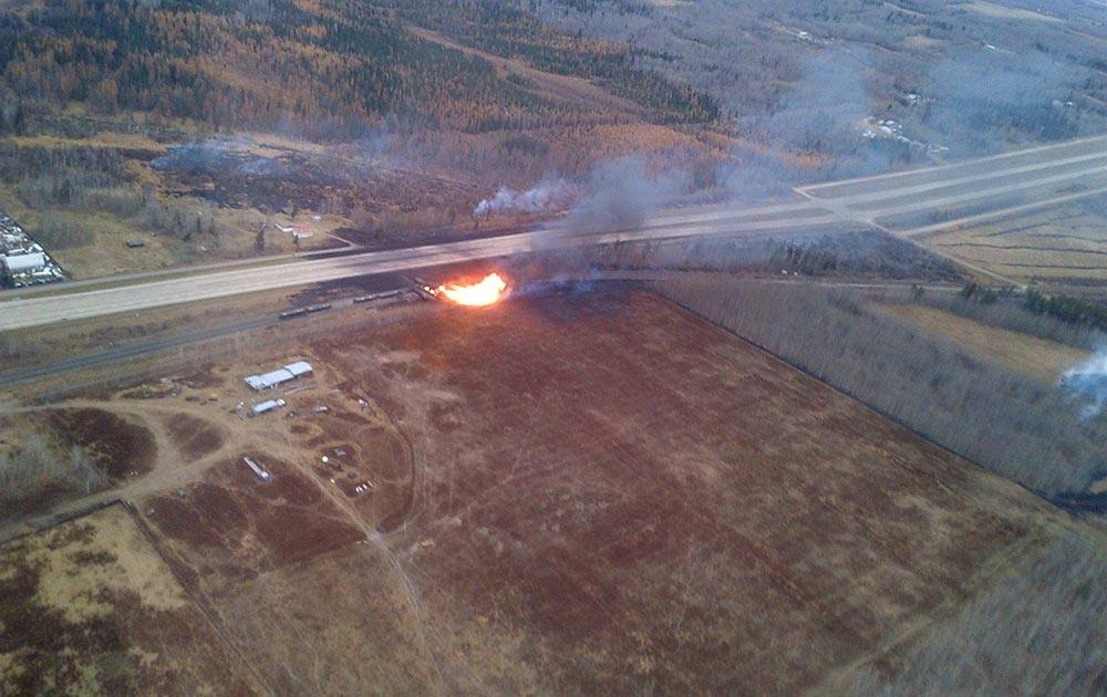 This photo provided by Royal Canadian Mounted Police, emergency crews work a massive fire after a CN tanker train carrying oil and gas derailed in Gainford, Alberta, Canada, west of Edmonton.