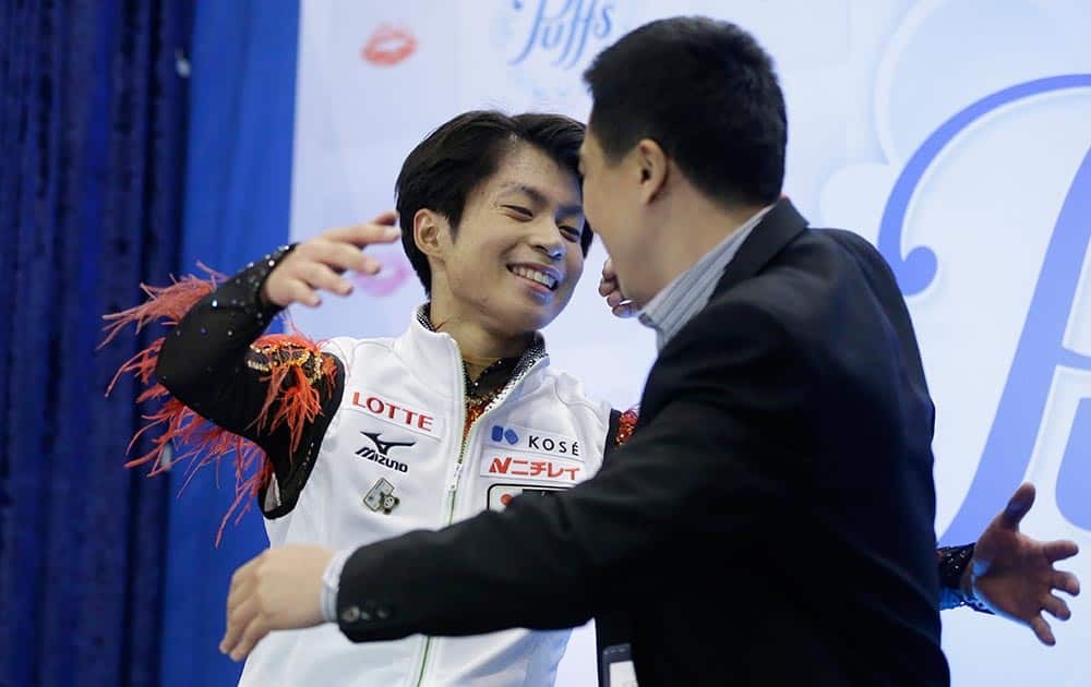 Tatsuki Machida of Japan hugs his coach Anthony Liu after winning the men`s free skate program at the Skate America figure skating competition in Detroit.