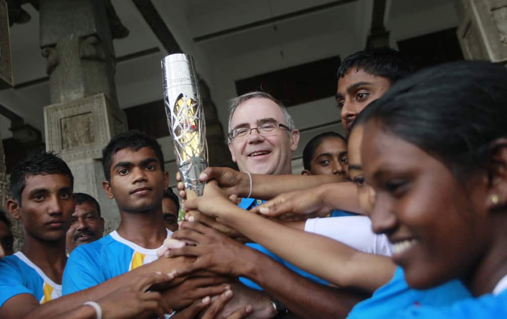British High Commissioner to Sri Lanka John Rankin holds the Queen`s Baton with aspiring Sri Lankan athletes during the baton rally in Colombo.