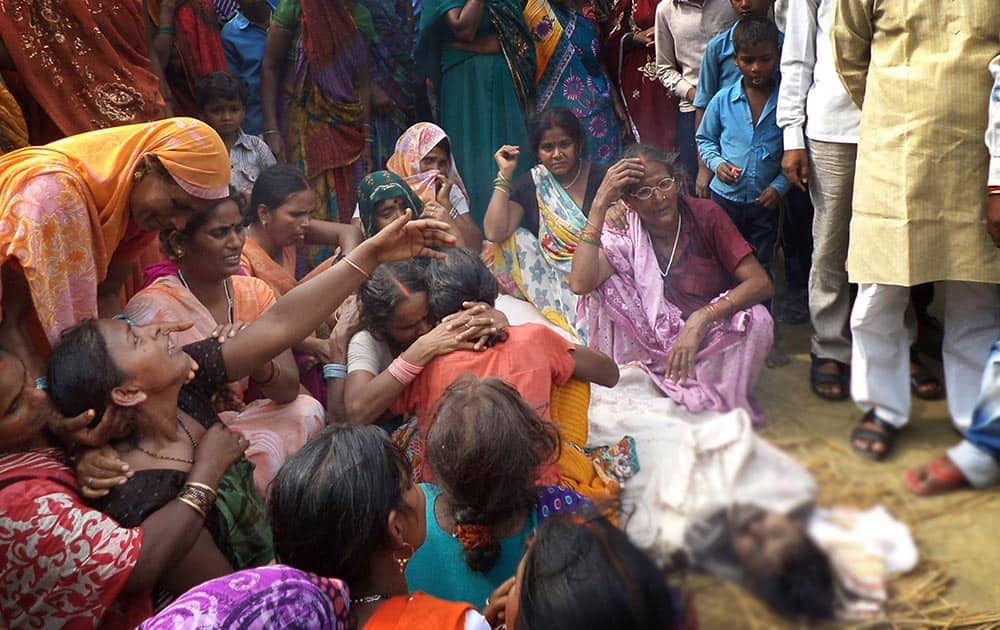 Relatives of an unidentified person died after drinking toxic liquor, wail near his body, in Adampur village, Uttar Pradesh.
