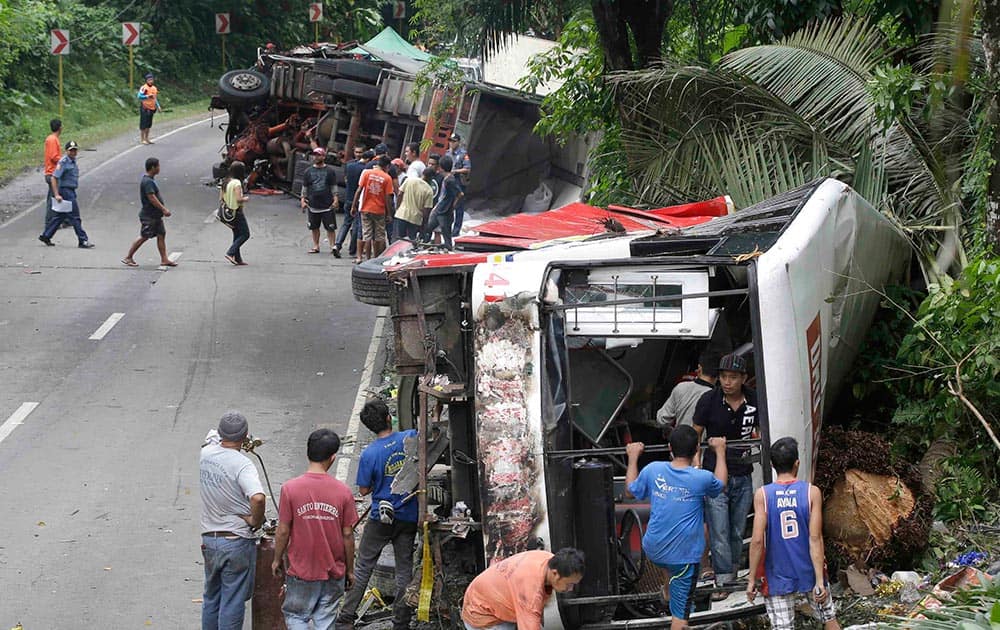 Workers sift through the wreckage of a passenger bus after getting involved in a seven-vehicle pile up along the highway at Atimonan township, Quezon province, about 115 kilometers southeast of Manila, Philippines.