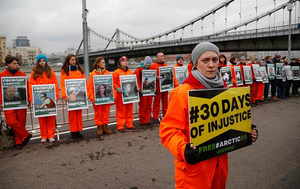 Russian Greenpeace activists display photos of arrested Greenpeace members during a protest in Moscow, Russia.
