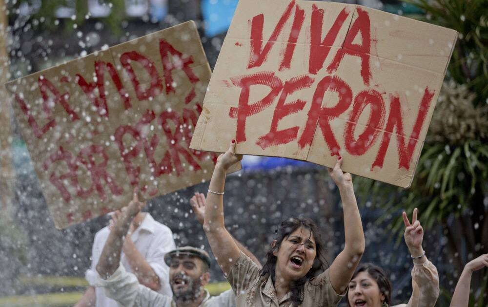 As Argentina`s President Cristina Fernandez recovers from surgery for a cranial blood clot, a supporter stands in the fountain at the Plaza de Mayo holding a banner that reads in Spanish;