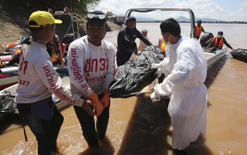 Thai rescuers unload a plane crash victim`s body from a boat in Pakse, Laos. Lao Airlines flight QV301 crashed Wednesday as it prepared to land in stormy weather at Pakse Airport in southern Laos.