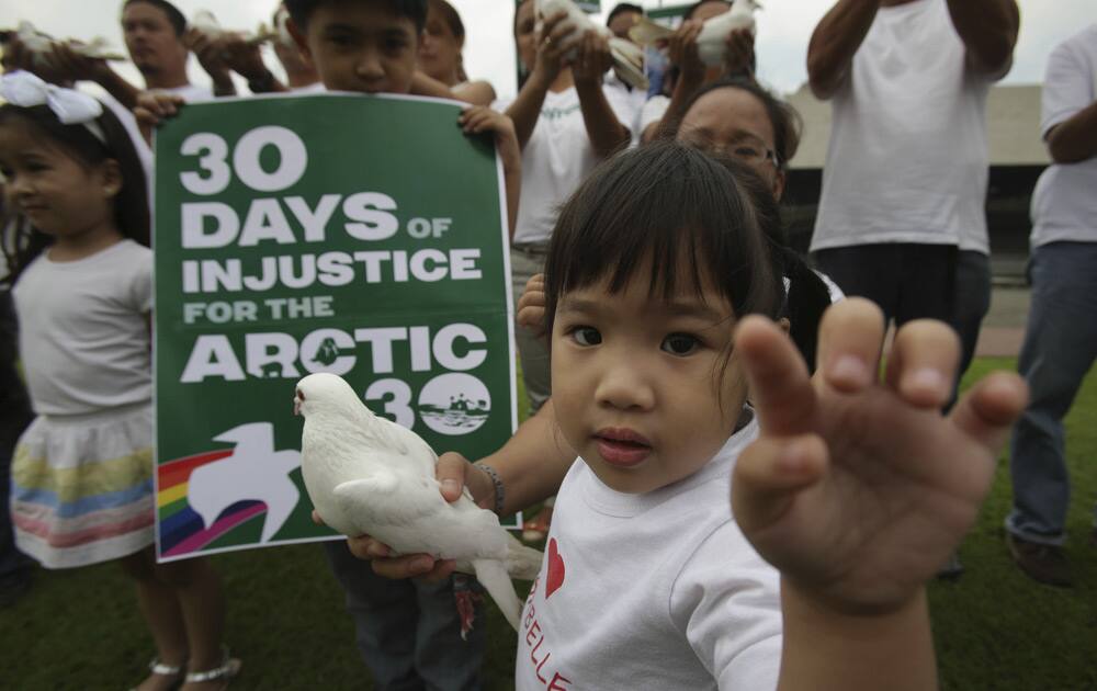 A Filipino girl tries to poke the lens of a photographer as she participates in a protest by Greenpeace activists outside the Cultural Center of the Philippines in Manila.