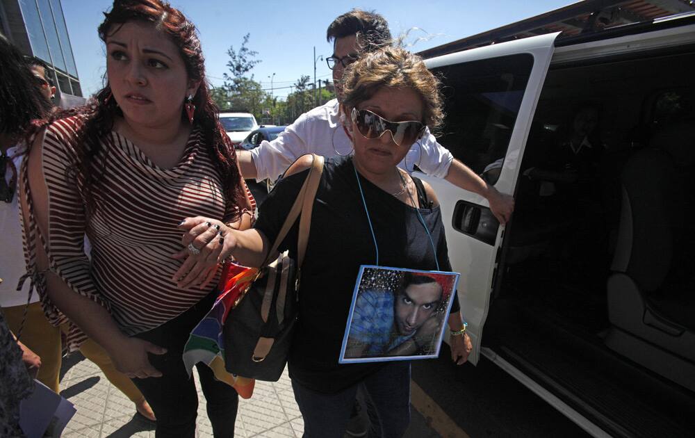 Jacqueline Vera wears a photograph of her son Daniel Zamudio as she leaves court after men were found guilty for her son`s murder in Santiago, Chile.