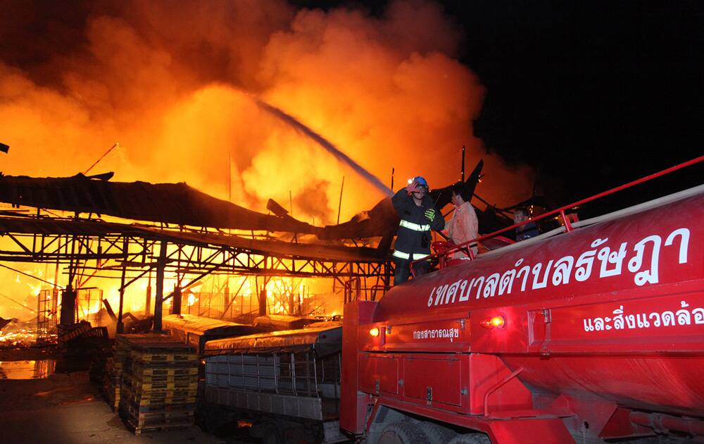 Thai firefighters try to extinguish the blaze that engulfs a warehouse on the compound of the SuperCheap store in Phuket, southern Thailand.