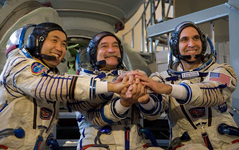 Japanese astronaut Koichi Wakata, Russian cosmonaut Mikhail Tyurin and NASA astronaut Rick Mastracchio shake hands before their final preflight practical examination in a mock-up of a Soyuz TMA space craft at Russian Space Training Center in Star City, outside Moscow, Russia.