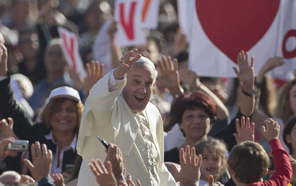 Pope Francis greets the faithful as he arrives for his weekly General Audience in St. Peter Square at the Vatican.