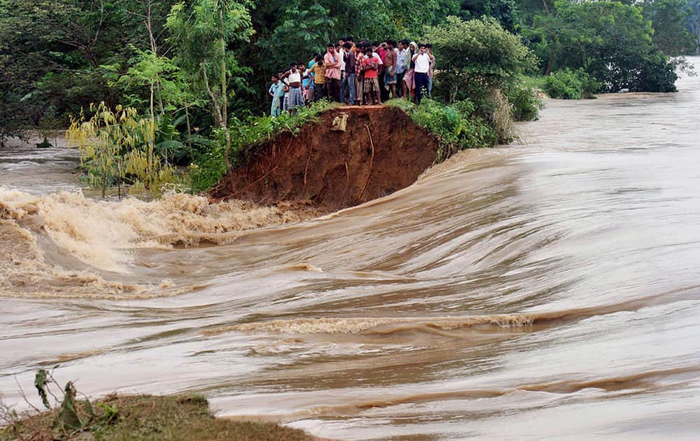 Villagers stand on the breached embankment of swollen Kangsabati river at Samat village in West Bengal state.