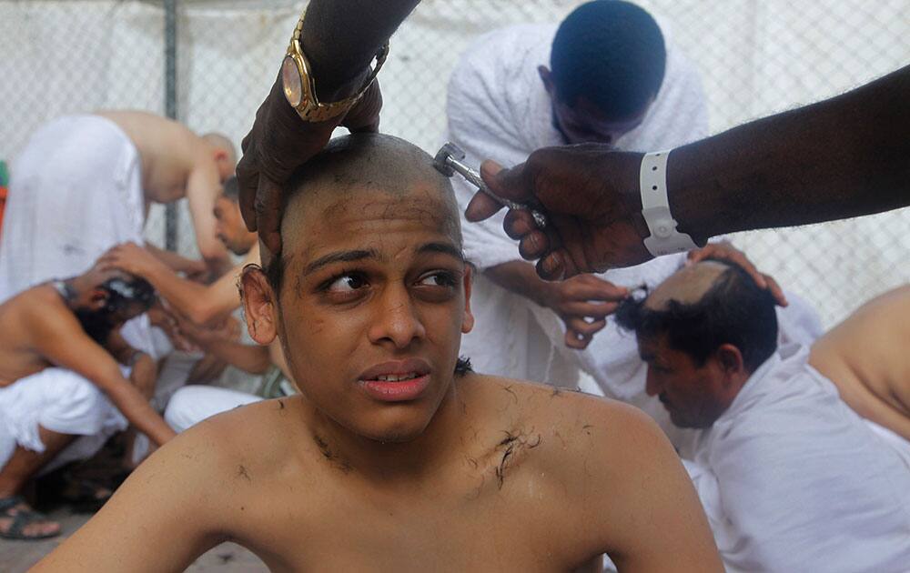 Saudi Muslim pilgrim, Gaiad al Harbi, 15, has his head ritually shaved after he casts stones at a pillar, symbolizing the stoning of Satan, in a ritual called