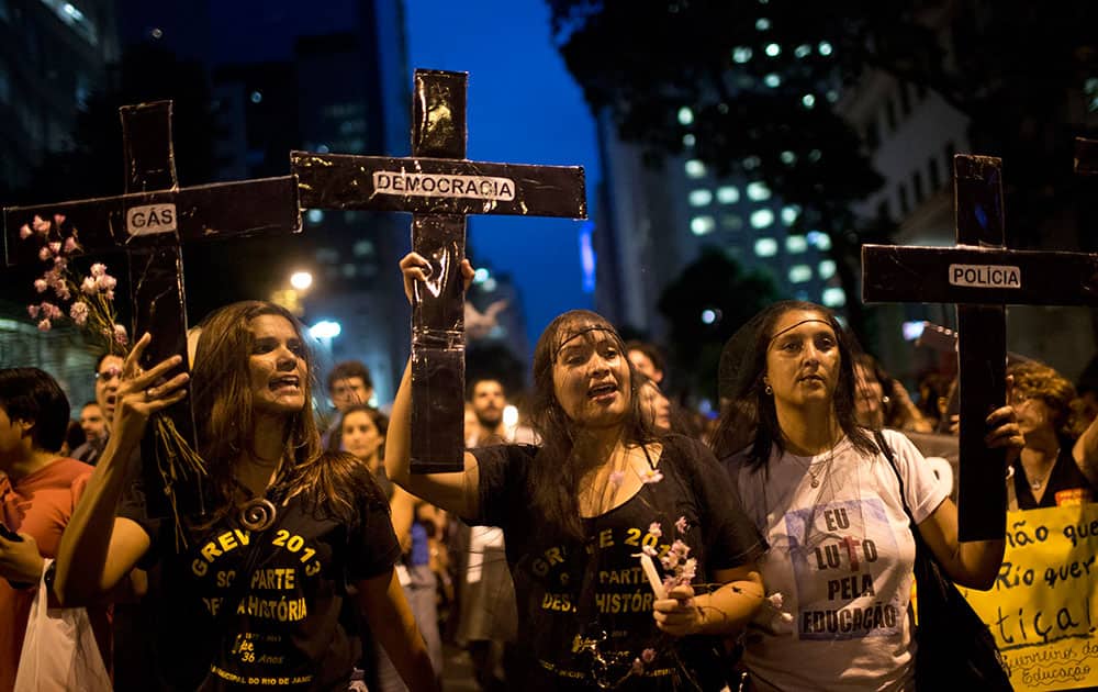 Striking teachers hold up crosses during a march on the nation`s teacher recognition day, in Rio de Janeiro, Brazil.