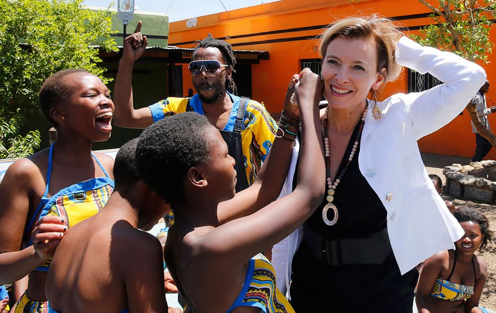 Children present a gift of earrings to Valerie Trierweiler, companion of French President Francios Hollande, during a visit to the Soweto Kliptown Youth (SKY) Centre in Soweto.