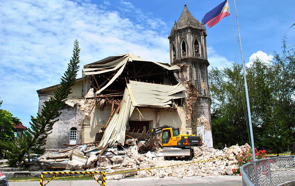 A crane shifts through the rubble of the damaged Our Lady of Assumption Parish church following a 7.2-magnitude earthquake, at Dauis in Bohol, central Philippines.