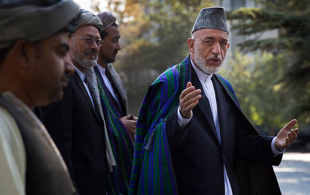 Afghan President Hamid Karzai arrives at a mosque inside the presidential palace to deliver his Eid al-Adha message, in Kabul, Afghanistan.