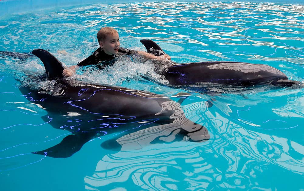 Daniil, 8, who suffers from hyperactivity, plays with dolphins during a dolphin-therapy session at a dolphinarium in Kiev, Ukraine. The dolphinarium organizes sessions for pregnant women, children and people with disabilities who are said to benefit from swimming and playing with the dolphins.