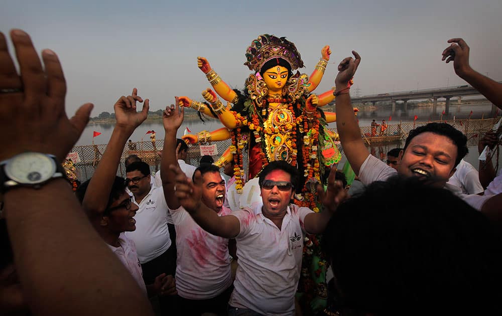 Indian Hindu devotees dance before immersing an idol of Hindu goddess Durga in the river Yamuna at the end of the Durga Puja festival, in New Delhi.