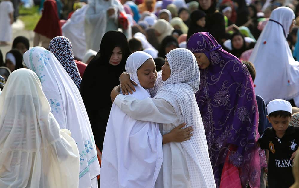 Filipino Muslims greet each other after offering early morning prayers in observance of Eid al-Adha, or